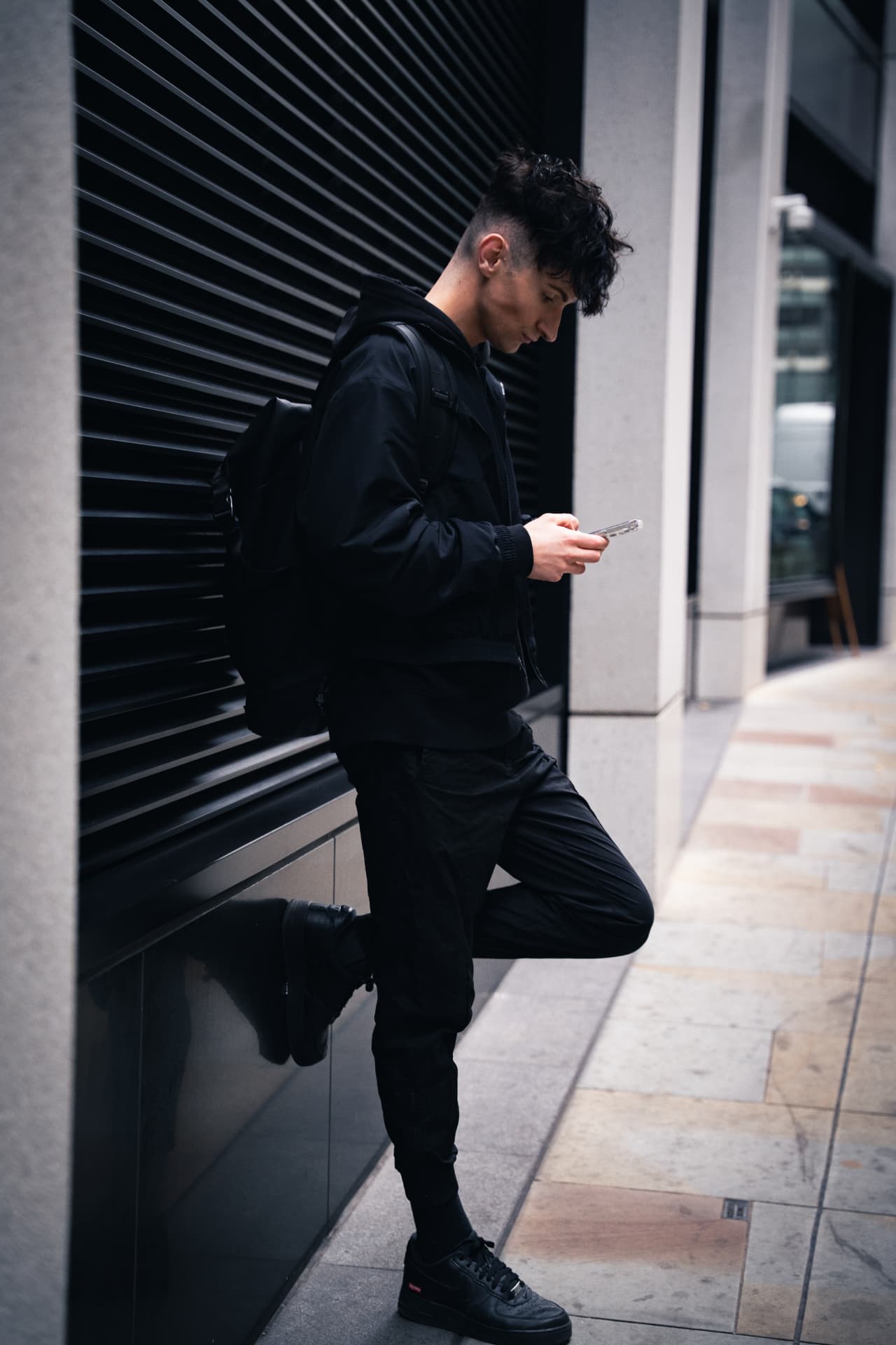 Stephen Chipping leaning against a black shuttered facade in the City of London